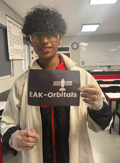 EAK-Orbitals engineer holding the company banner in the lab